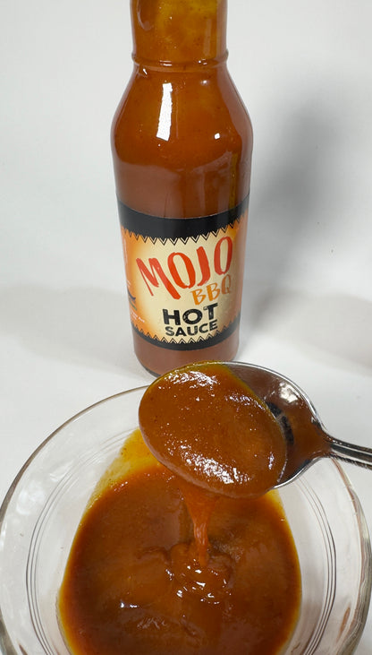 Mojo BBQ Hot Sauce poured on a spoon showing rich smoky texture - Purple Pepper Farms craft BBQ sauce