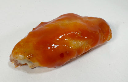 Chicken wing glazed with Screaming Bees Hot Sauce close-up - Purple Pepper Farms honey cayenne hot sauce on wings